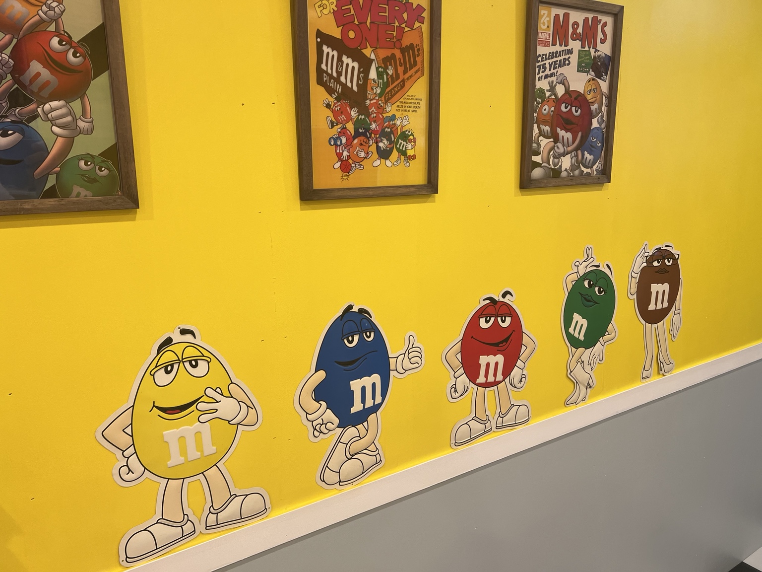 黄色い壁に飾られたM＆M’sのキャラクターとポスター