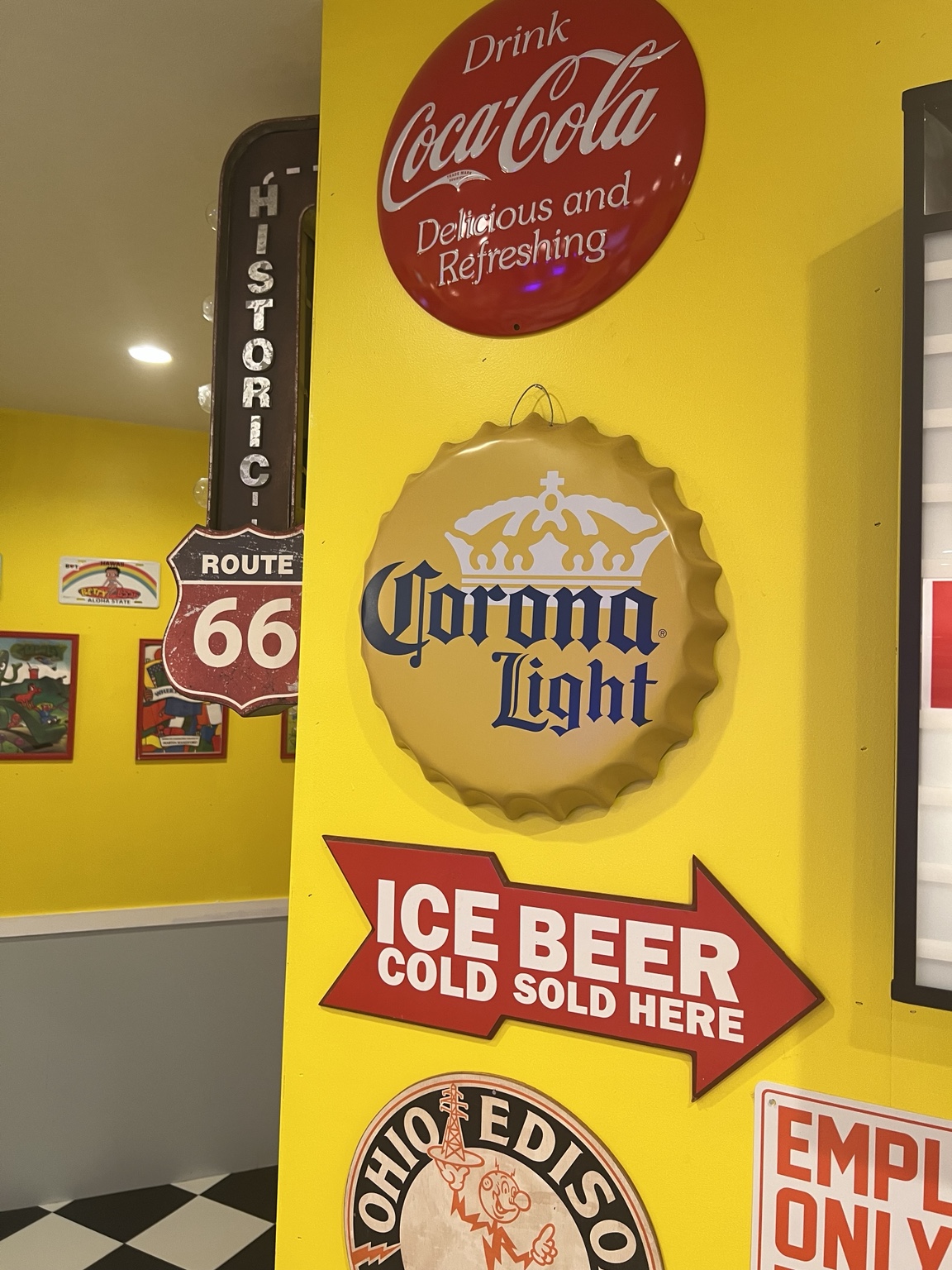 黄色い壁に並ぶコカ・コーラ、Corona、ROUTE 66のサイン